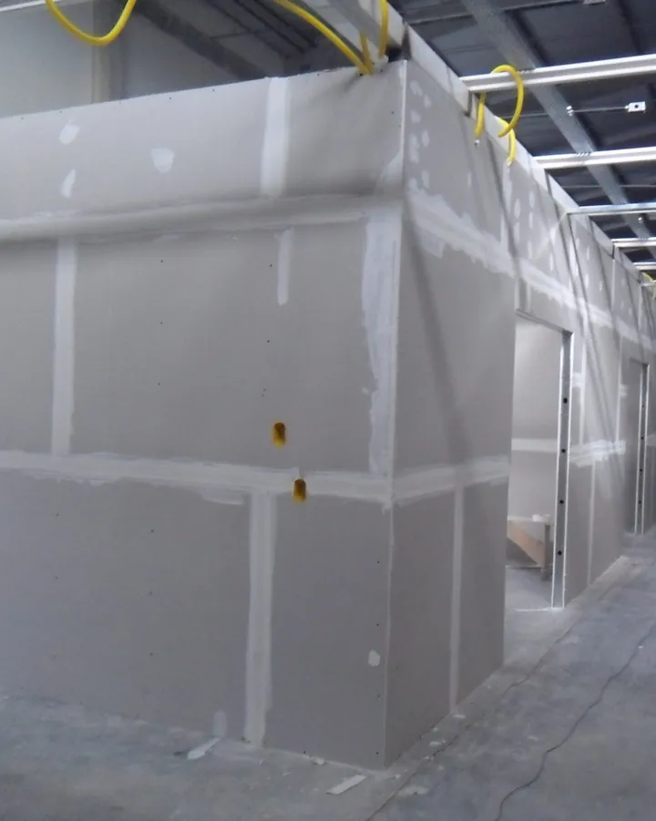 Paredes de drywall com juntas tratadas em corredor de galpão