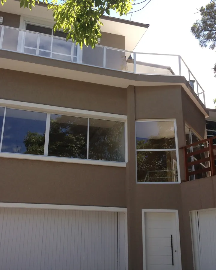 Fachada residencial de três pavimentos com revestimento texturizado