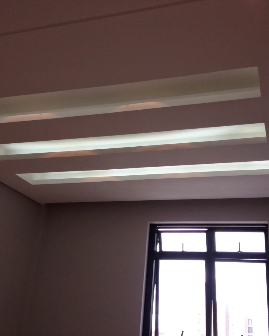 Forro de gesso com rebaixos lineares iluminados, obra concluída
