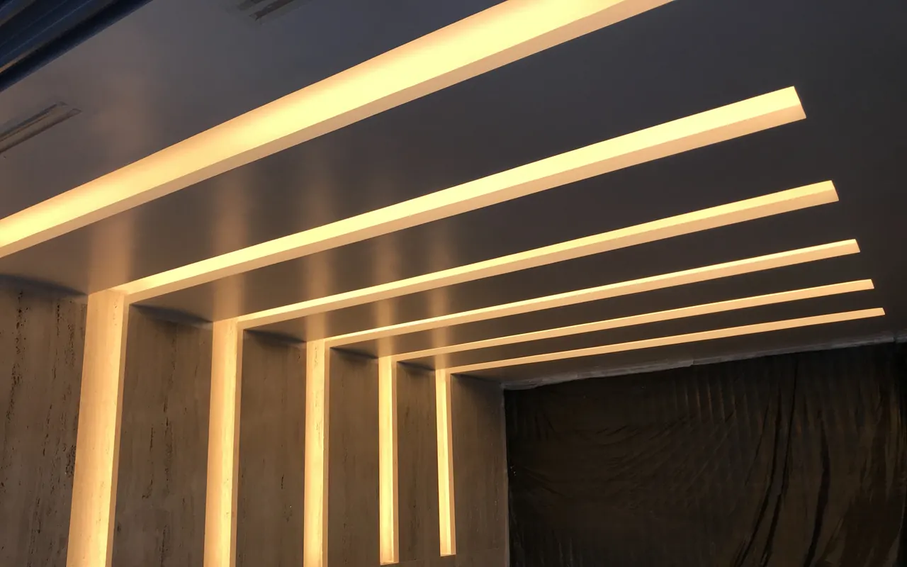 Forro de gesso com perfis de luz linear embutidos em sequência, executado pela Gesso Camargo