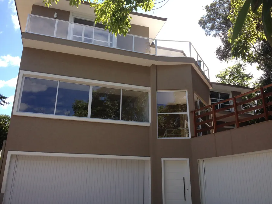 Fachada residencial de três pavimentos com revestimento texturizado