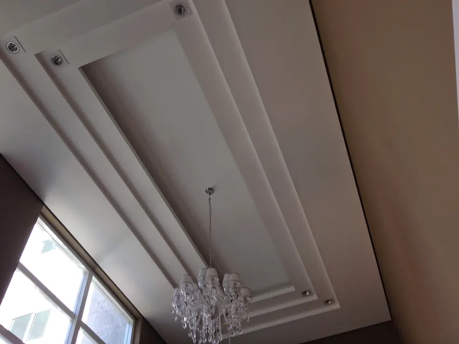 Forro de gesso com sancas em camadas e lustre de cristal