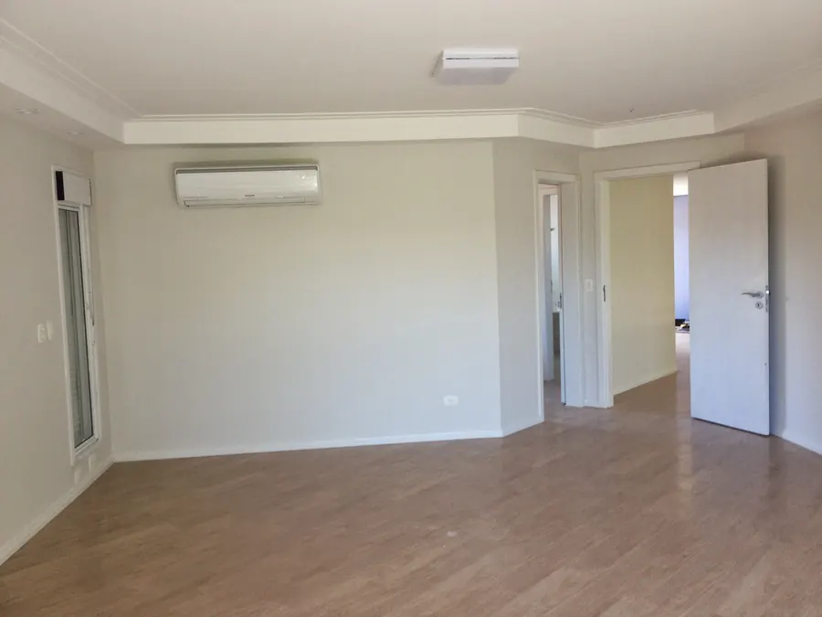 Quarto com piso laminado amadeirado e paredes recém pintadas